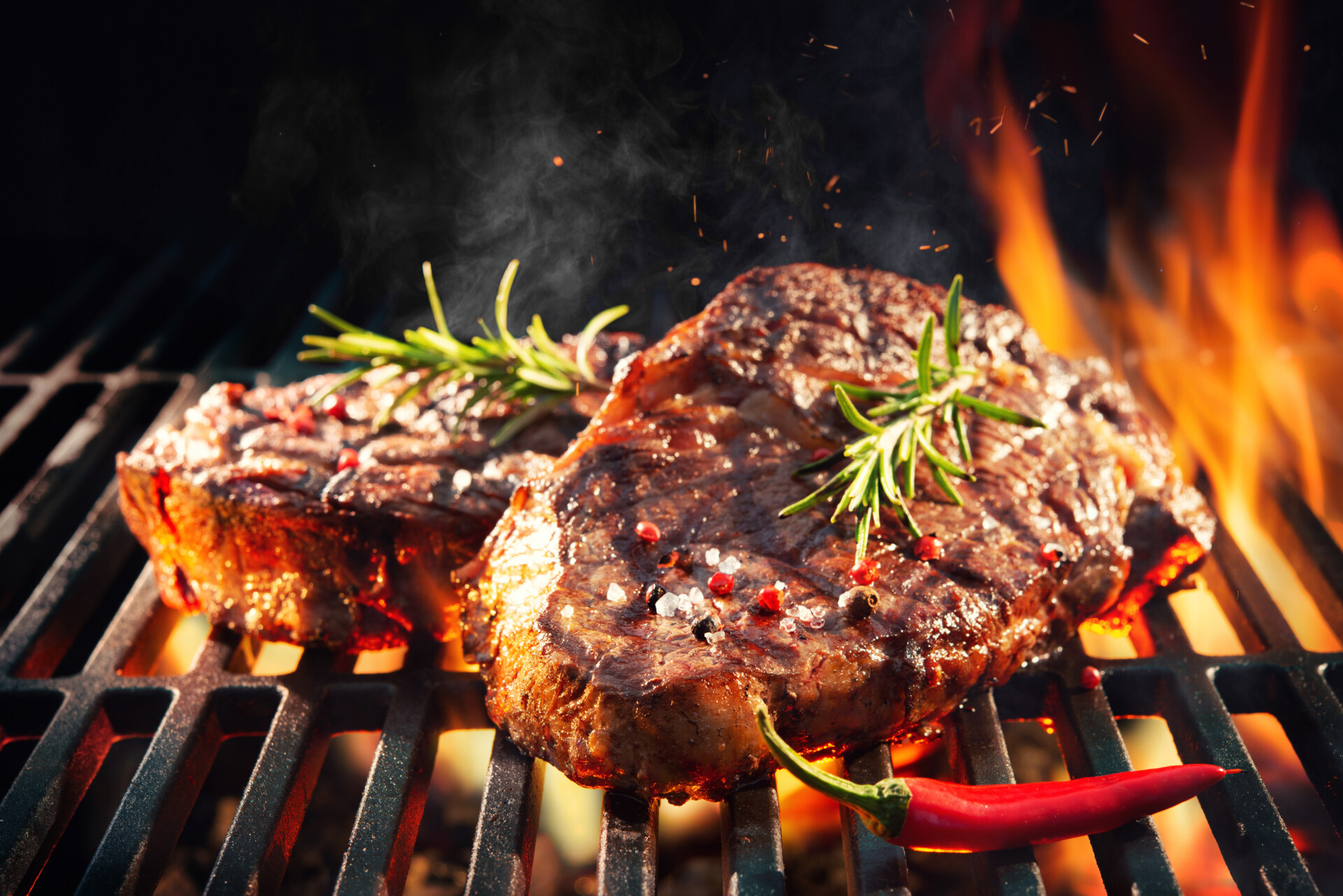 Beef,Steaks,Sizzling,On,The,Grill,With,Flames